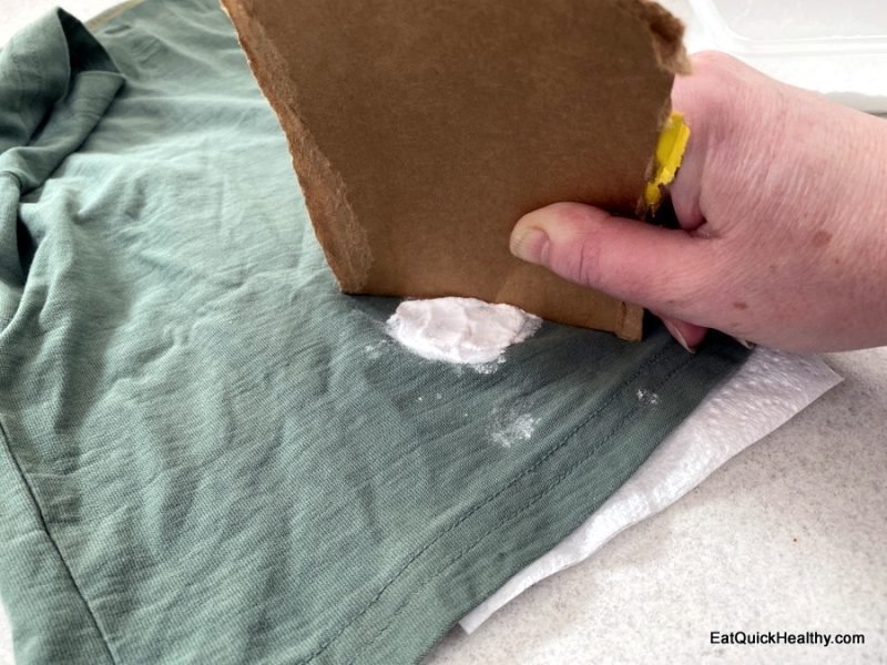 Scraping off the baking soda with cardboard